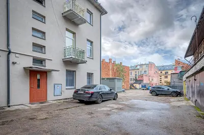 two cars parked in a parking lot next to a building at The Comfort Apartment #1 by Polo Apartments in Kaunas
