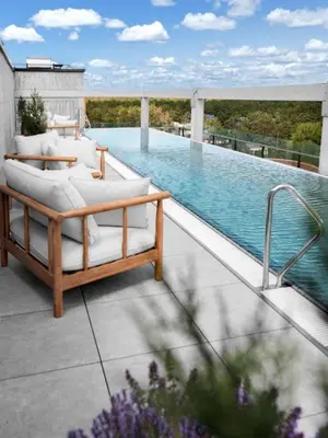 a patio with a swimming pool with a couch and a bed at Pušų nata in Druskininkai