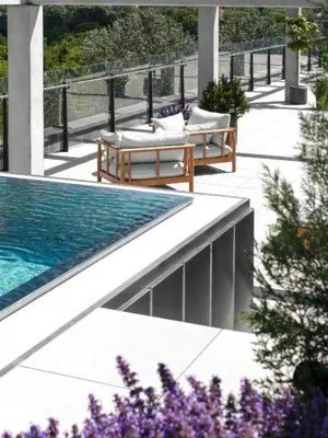 a patio with two benches and a swimming pool at Pušų nata in Druskininkai