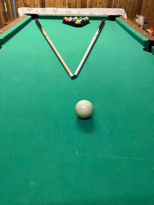 a green pool table with two cue sticks on it at Beloved Family Nest in Vosyliukai