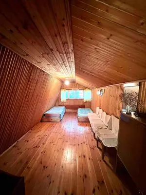a room with wooden floors and a room with couches in a room at Beloved Family Nest in Vosyliukai