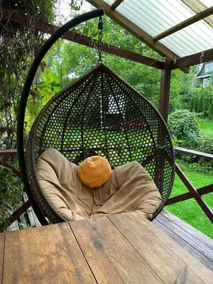 a teddy bear sitting in a swing on a porch at Beloved Family Nest in Vosyliukai