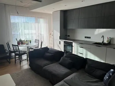 a living room with a couch and a kitchen with a table at My home Vilnius in Vilnius