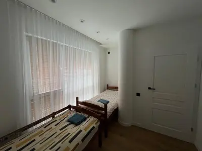a bedroom with two beds and a large window at My home Vilnius in Vilnius