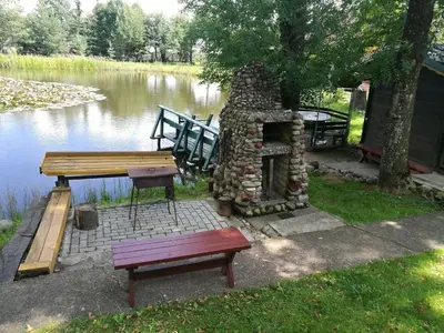 a picnic table and a bench next to a lake at Kaimo turizmo sodyba