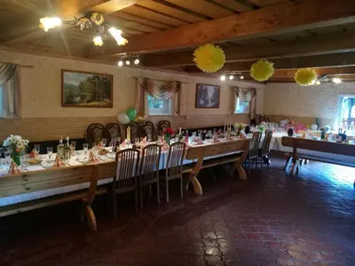 a dining room with a long table and chairs at Kaimo turizmo sodyba