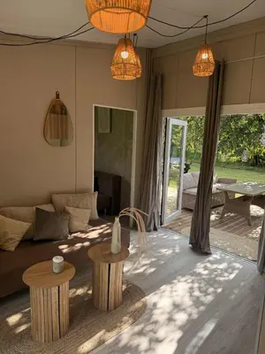 a living room with a couch and two tables at Forest Resort house