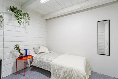 a white bedroom with a bed and a table at STAY Kaunas city center in Kaunas