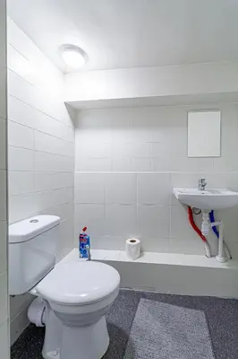 a white bathroom with a toilet and a sink at STAY Kaunas city center in Kaunas