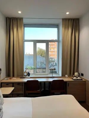 a bedroom with a desk and a large window at Modern Room in Central Vilnius in Vilnius