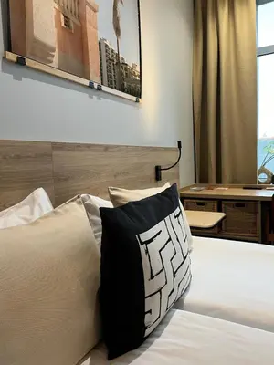 a bed with a black and white pillow on it at Modern Room in Central Vilnius in Vilnius
