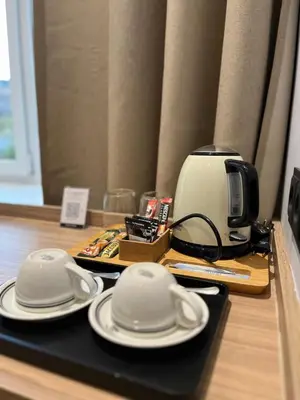 a table with white plates and a coffee maker at Modern Room in Central Vilnius in Vilnius