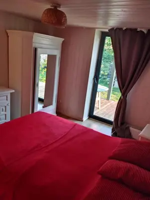a bedroom with a red bed and a sliding glass door at Namelis soduose in Akademija