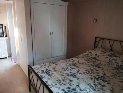 a bedroom with a bed with a floral bedspread at Namelis soduose in Akademija