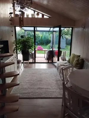 a living room with a couch and a sliding glass door at Namelis soduose in Akademija