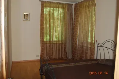 a bedroom with a bed and a window with curtains at Ramuma in Vilnius
