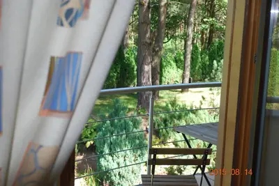 a room with a balcony with a view of a forest at Ramuma in Vilnius