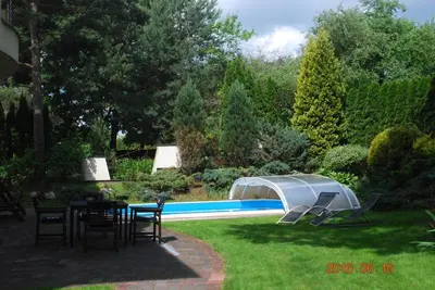 a garden with a table and chairs next to a pool at Ramuma in Vilnius