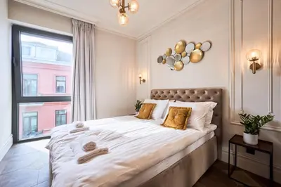 a bedroom with a large bed with a large window at Old Town Pearl Suite in Kaunas