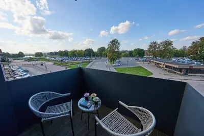 a balcony with two chairs and a table with flowers at Old Town Pearl Suite in Kaunas