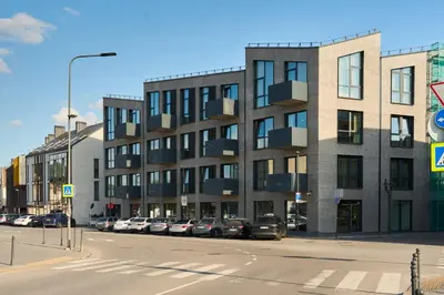 a large building with cars parked in a parking lot at Old Town Pearl Suite in Kaunas