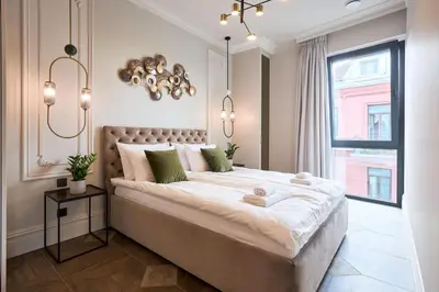 a bedroom with a large bed and a window at Old Town Pearl Suite in Kaunas