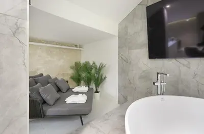 a bathroom with a couch and a sink and a tv at Provokatas in Kaunas