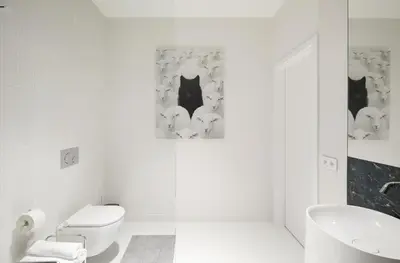 a white bathroom with a toilet and a sink at Provokatas in Kaunas
