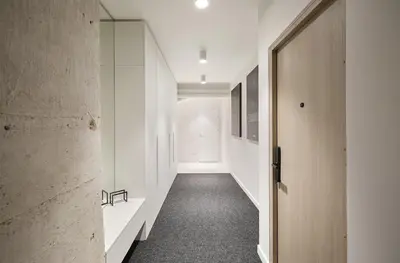 a hallway with white walls and a door at Provokatas in Kaunas