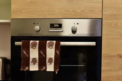 an oven with a clock and a towel on it at Domillion 2bdr 2bath on Vokieciu w parking V1020A in Vilnius