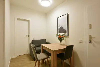 a dining room with a table and chairs and a chair with flowers at Domillion 2bdr 2bath on Vokieciu w parking V1020A in Vilnius