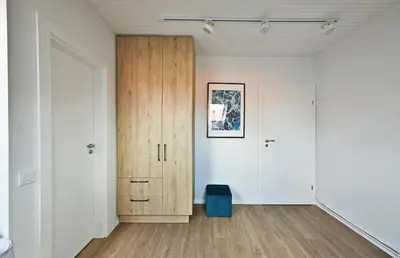 a room with white walls and a wooden cabinet at Domillion 2bdr 2bath on Vokieciu w parking V1020A in Vilnius