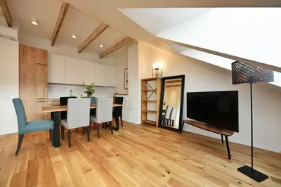 a dining room with a table with chairs and a television at Domillion Penthouse 2bdr 2bath P364a in Vilnius
