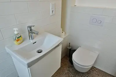 a white bathroom with a sink and a toilet at Domillion Penthouse 2bdr 2bath P364a in Vilnius
