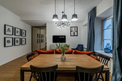 a dining room and living room with a table and chairs at Domillion new modern 2bdr City Hall apt D1117B in Vilnius
