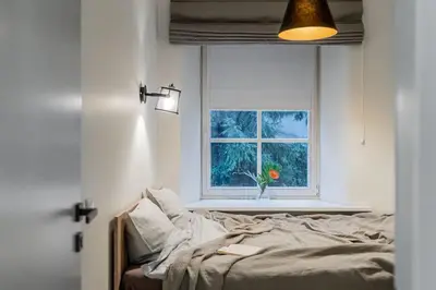 a bedroom with a bed and a window at Domillion new modern 2bdr City Hall apt D1117B in Vilnius