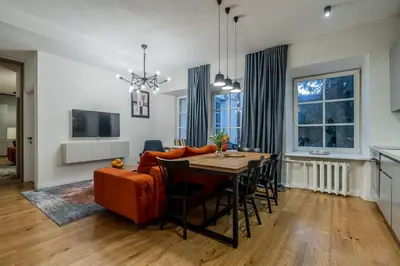 a living room with a table and a couch at Domillion new modern 2bdr City Hall apt D1117B in Vilnius