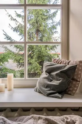 a window sill with a pillow and candles in front of it at Domillion new modern 2bdr City Hall apt D1117B in Vilnius