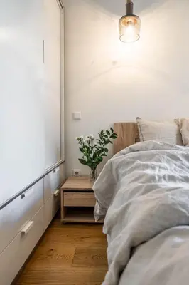 a bedroom with a bed and a table with a plant at Domillion new modern 2bdr City Hall apt D1117B in Vilnius