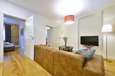 a living room with a couch and a television at Domillion 2bdr President Palace free parking L417 in Vilnius