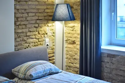 a bedroom with a bed with a lamp and a brick wall at Domillion 2bdr President Palace free parking L417 in Vilnius