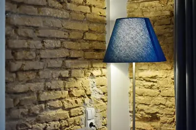 a blue lamp sitting next to a brick wall at Domillion 2bdr President Palace free parking L417 in Vilnius