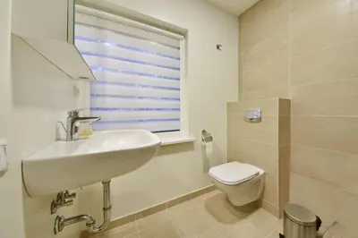 a bathroom with a sink and a toilet and a window at Domillion 3bdr 2baths President Palace park L419A in Vilnius