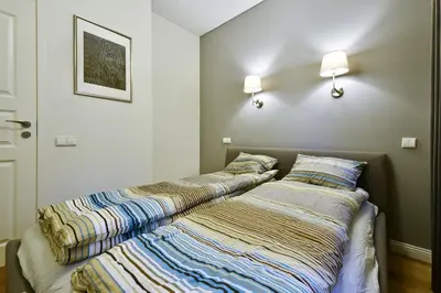 two beds sitting next to each other in a bedroom at Domillion 3bdr 2baths President Palace park L419A in Vilnius
