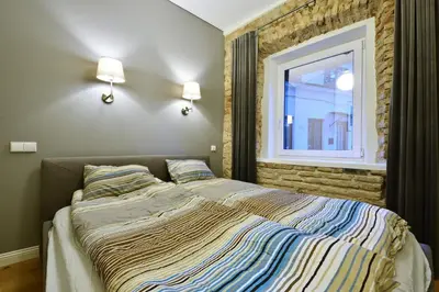 a bedroom with a large bed with a window at Domillion 3bdr 2baths President Palace park L419A in Vilnius