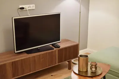 a flat screen tv sitting on top of a wooden entertainment center at Domillion 3bdr 2baths President Palace park L419A in Vilnius