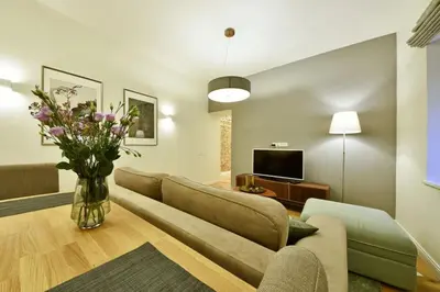a living room with a couch and a vase of flowers at Domillion 3bdr 2baths President Palace park L419A in Vilnius