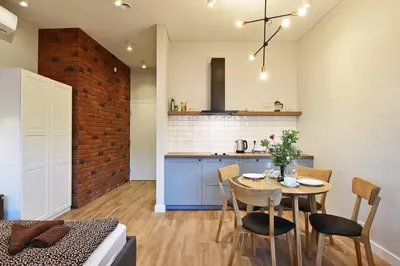 a kitchen and dining room with a table and chairs at Domillion New modern Vilnius old town studio U2302 in Vilnius