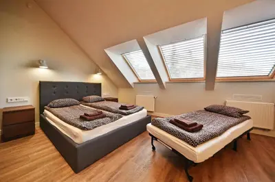 two beds in a room with two windows at Domillion New modern Vilnius old town studio U2303 in Vilnius