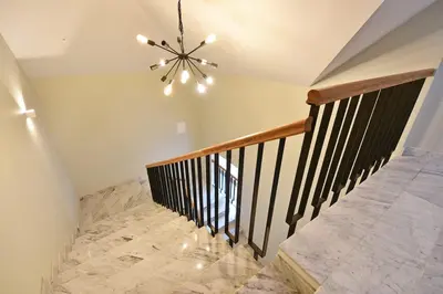 a staircase with a chandelier and marble floor at Domillion New modern Vilnius old town studio U2303 in Vilnius